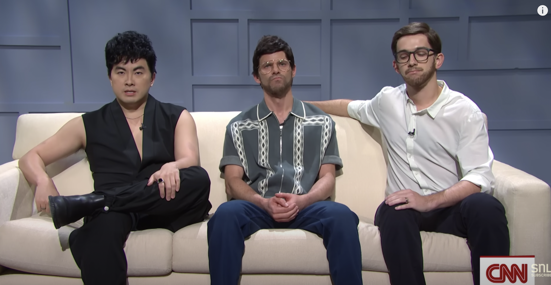 A screenshot of three Saturday Night Live male comedians, dressed as the YouTubers Try Guys and sitting on a cream-colored sofa, addressing their viewers.